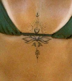 a woman's stomach with a tattoo on the side and an arrow in the middle