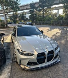 two cars parked next to each other on the side of the road in front of a bridge