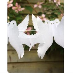 some white paper birds hanging from a tree