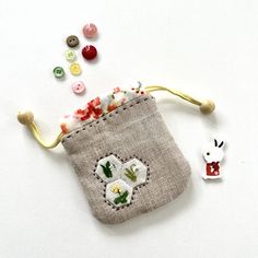 a small pouch with buttons and thread in it