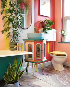 a bathroom with a toilet, tub and potted plants