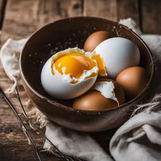 an egg cracked in half on a wooden table with utensils next to it