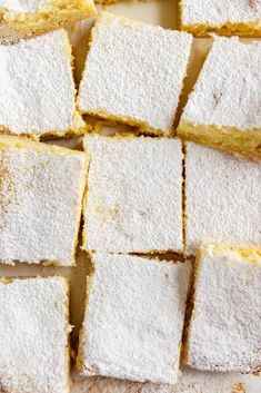 several pieces of cake sitting on top of a white plate with powdered sugar toppings