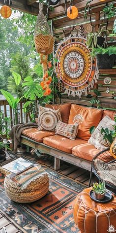 an outdoor living room with lots of plants and decorations on the wall, including couches