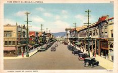 an old postcard shows cars driving down the street