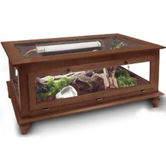 an aquarium in a wooden stand with rocks and plants on it's bottom shelf