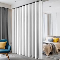 a blue chair sitting in front of a window next to a white curtained wall