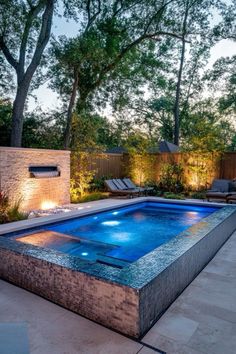 an outdoor swimming pool surrounded by trees and lights