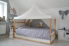 a bed with a white canopy over it in a room next to an oven and window