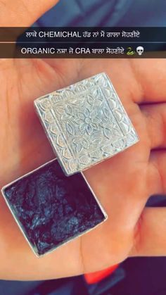 two pieces of silver and black stone in the palm of someone's hand