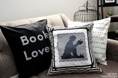 two black and white pillows sitting on top of a couch next to a birdcage