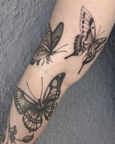 a woman's arm with two butterflies on it, one is black and the other is white