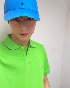 a boy wearing a green shirt and blue hat