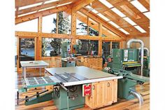 a table sawing in a wood shop with lots of windows and wooden flooring