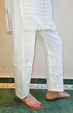 Cotton pants with pleated inserts and embroidered in chikankari. Pockets. Length - Inseam - Sizes - S - fits 36 upto 40 waist M - fits 38 upto 42 waist L - fits 40 upto 44 waist XL - fits 42 upto 46 waist Traditional White Bottoms, Traditional White Long Pants, Traditional Set With Chikankari Embroidery And Wide Leg, Summer Cotton Pants With Chikankari Embroidery, Traditional White Wide Leg Bottoms, Traditional White Trousers, Summer Cotton Bottoms With Lace Work, Spring Cotton Bottoms With Lace Work, Spring White Pants With Chikankari Embroidery