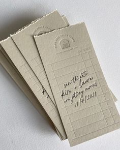 three envelopes with writing on them sitting next to each other in front of a white wall