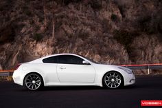 a white sports car parked in front of a mountain