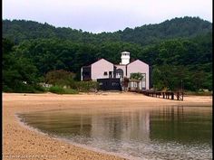 a white house sitting on top of a sandy beach next to a body of water