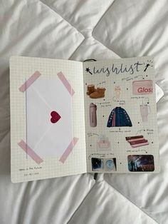 an open notebook with stickers and pictures on the cover, sitting on a bed