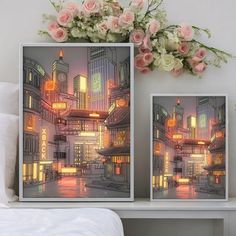 two framed pictures sitting on top of a bed next to a vase filled with flowers