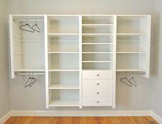 an empty closet with white shelves and shoes on the wall, in front of a hardwood floor