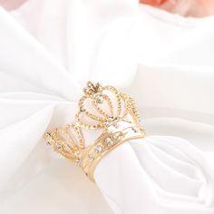 a gold crown ring sitting on top of a white cloth