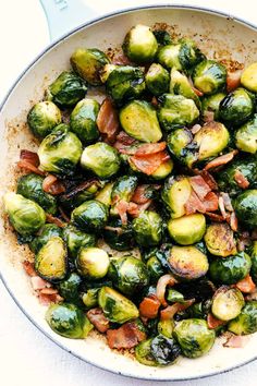 brussel sprouts with bacon in a skillet on a white surface