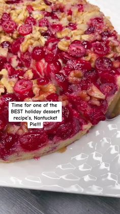 a pie with cranberries and nuts on it sitting on top of a white plate