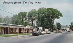 an old postcard shows cars parked in front of shops on the corner of a street