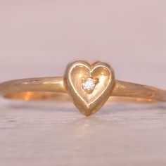 The Fifty: Natural Diamond Heart Ring In Yellow Gold. This Simple Ring Centers On A Round-Cut Natural Diamond, Beautifully Set Within A Concave Heart Shape Crafted In Yellow Gold. Currently Sized At 5.25, The Ring Can Be Adjusted To Fit Any Finger Size For An Additional Fee Upon Request, Ensuring A Perfect Fit. Classic Heart Ring With Single Diamond, Heart-shaped Single Diamond Ring Gift, Heart Shaped Single Diamond Ring For Gift, Heart Shaped Single Diamond Gift Ring, Heart-shaped Single Diamond Gift Ring, Heart-shaped Diamond Ring With Single Diamond, Heart-shaped Diamond Ring With Single Stone, Heart-shaped Single Diamond Jewelry For Promise, Heart-shaped Single Diamond Promise Ring