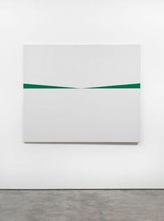 an abstract painting hangs on the wall next to a white and green piece of artwork