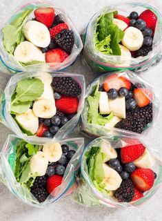 six plastic containers filled with different types of fruits and veggies on top of a table