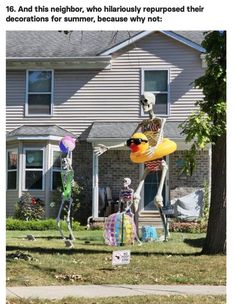 two skeleton statues in front of a house with an inflatable balloon on the lawn