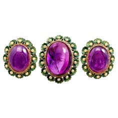 A fine and impressive 39.82 carat amethyst (total) and green enamel, 18 karat yellow gold jewelry set; part of our diverse vintage jewelry and estate jewelry collections. This exceptional 1930s cabochon cut jewelry set consists of a stunning amethyst cocktail ring accompanied by an impressive pair of matching earrings. The feature high profile, pierced decorated setting is ornamented with a stunning bezel set 20.90Ct cabochon amethyst held in subtle relief to the center of the design. The amethy Antique Amethyst Jewelry, Green Gold Jewelry, Antique Amethyst Ring, Amethyst Jewelry Set, Jewelry History, Amethyst Jewellery, Amethyst Cocktail Ring, Gold Jewelry Set, Enamel Jewellery