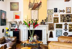 a living room filled with furniture and pictures on the wall next to a fire place