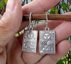 Beautifully detailed Tarot Cards dangle from silver plate Lever Back Ear Wires. The Sun and La Luna are depicted on a pair of double sided silver tarot cards. One of my very favorite designs, these fortune teller earrings are both elegant and edgy, a perfect combination and the ideal gift for mystical folks on you list.  Your Tarot Card Earrings will arrive in an organza pouch with a matching polishing cloth.  Use code 3GETS20 to receive a 20% discount every time you order 3 or more items from A Tarot Card Earrings, Tarot Earrings, Card Earrings, Earrings Goth, Handmade Clay Jewelry, Dragon Earrings, Earrings Ideas, Organza Pouch, Fortune Teller