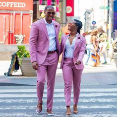 two people in pink suits walking down the street