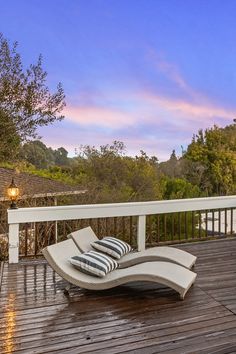 an outdoor lounge chair sitting on top of a wooden deck