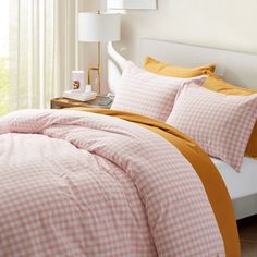 a bed with pink and yellow comforters in a bedroom