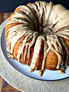 a bundt cake on a plate with icing drizzled around it