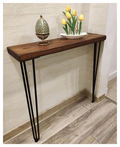 a wooden table with black hairpinks on top and flowers in vases next to it