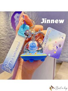 a person holding a keychain that has various items attached to it, including a card