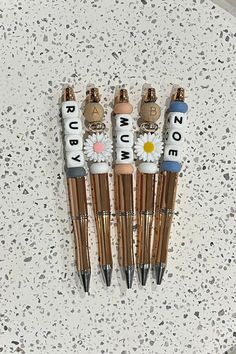 four pens with writing on them sitting next to each other in the shape of flowers