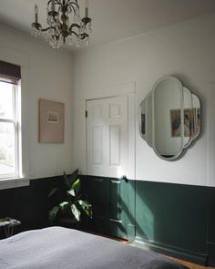 a bedroom with a bed, mirror and potted plant