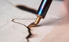 a close up of a person writing with a fountain pen