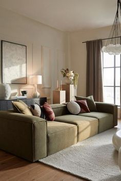 a living room filled with lots of furniture and pillows on top of a wooden floor