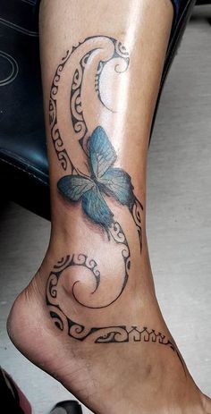 a woman's foot with a butterfly tattoo on the top and bottom part of her leg