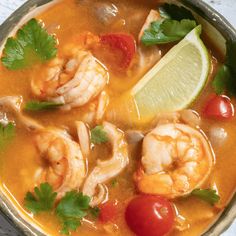 a bowl filled with shrimp, tomatoes and cilantro