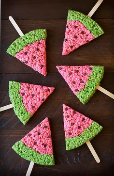 four slices of watermelon cake sitting on top of wooden skewers with green and pink sprinkles