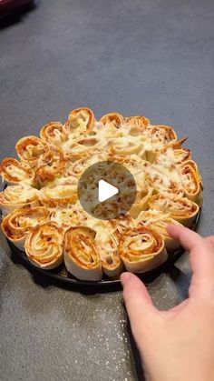 someone is pointing at a pie in the middle of a pan with some food on it